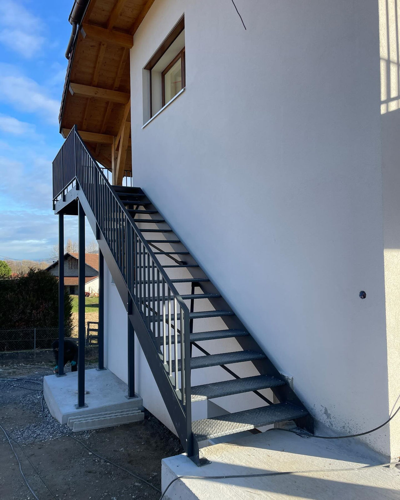 Escalier acier et bois adossé à un mur en pierre